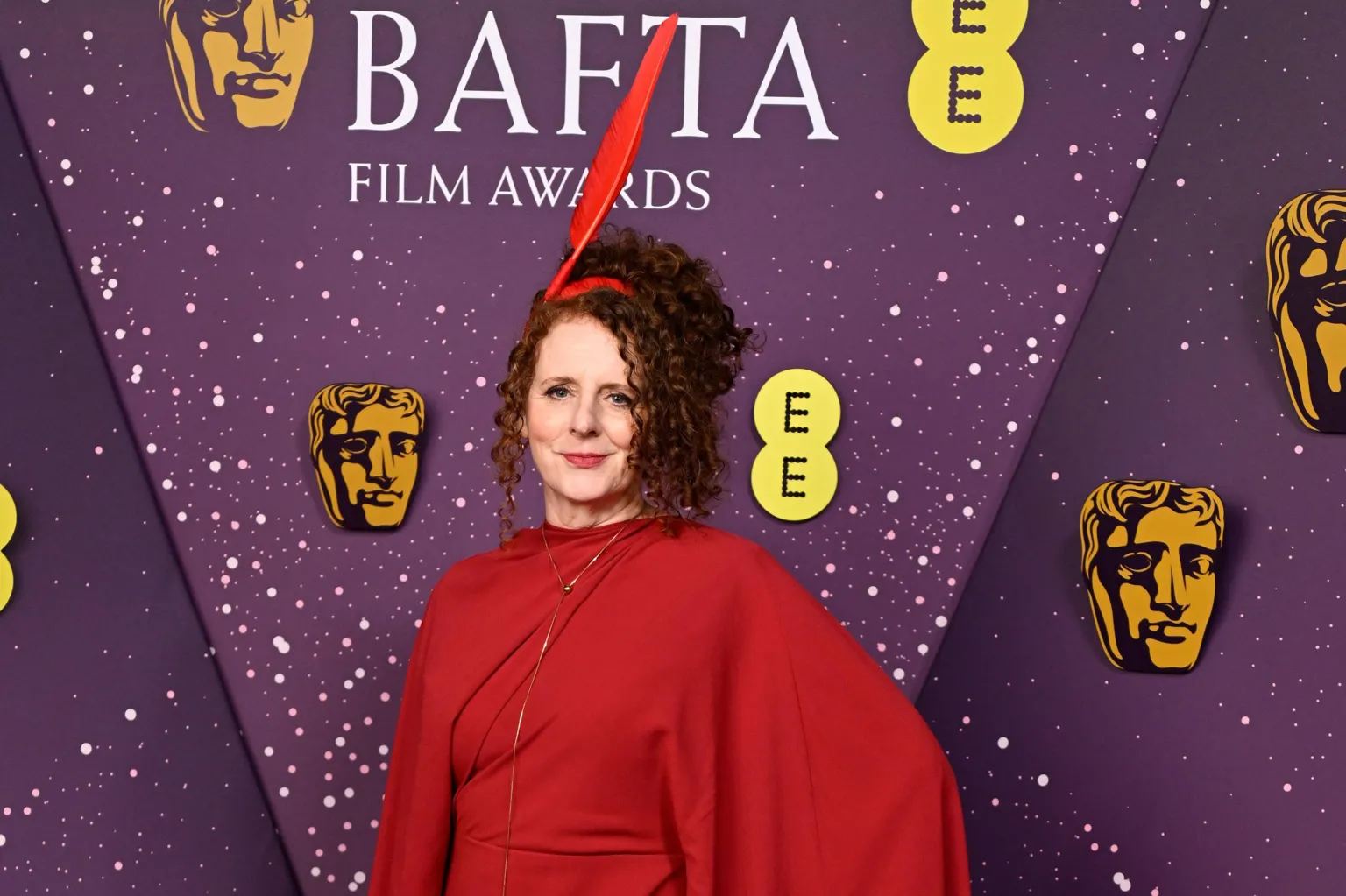 Getty Images Maggie O'Farrell in a red dress with a red quill headpiece