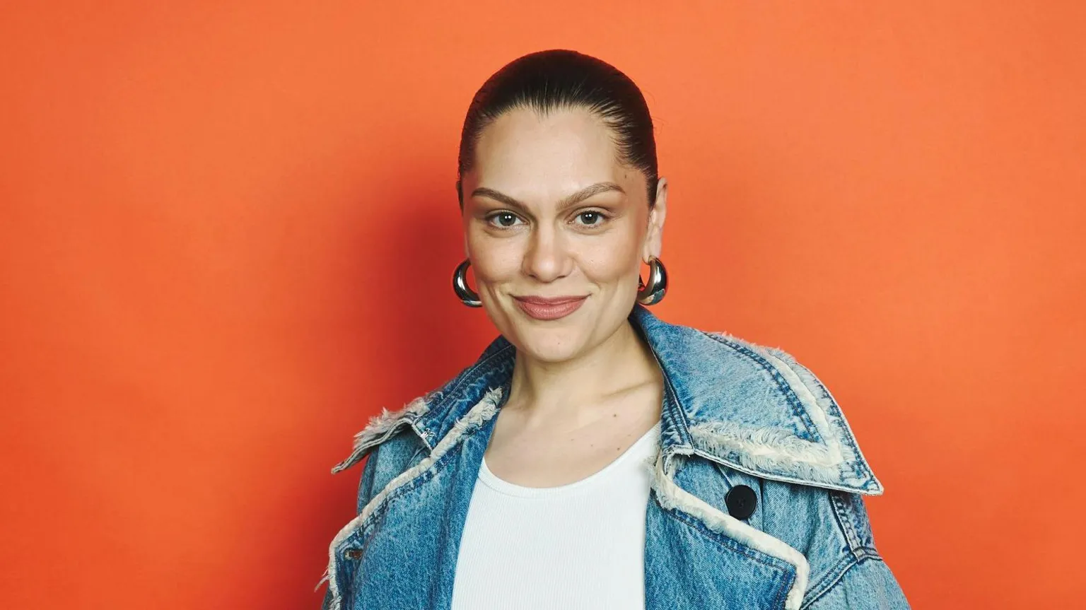 BBC Jessie J with her hair tied back, big silver hoop earrings and a denim jacket and white top