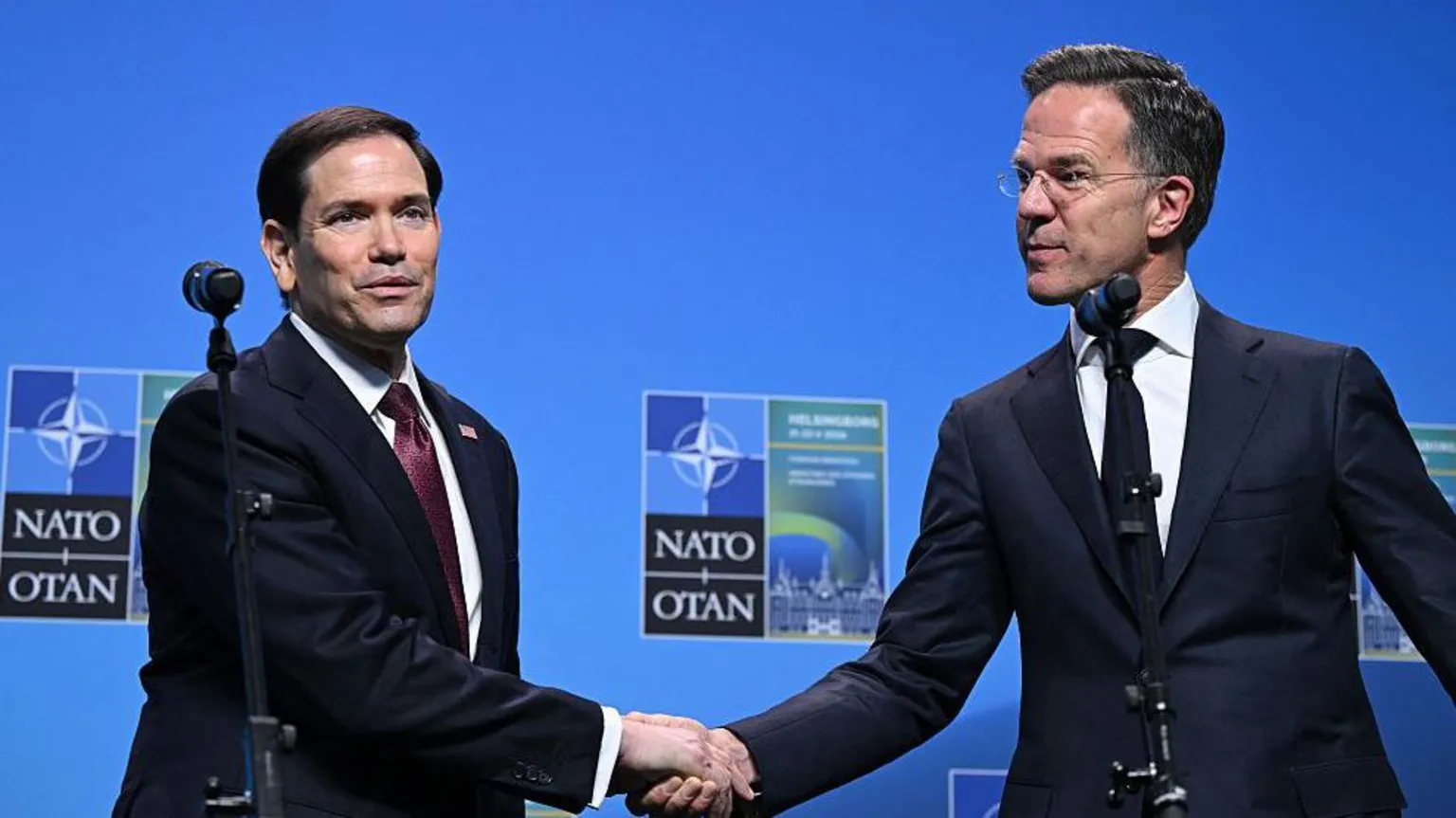 AFP via Getty Images Nato Secretary General Mark Rutte (R) and US Secretary of State Marco Rubio shake hands in front of a blue Nato backdrop
