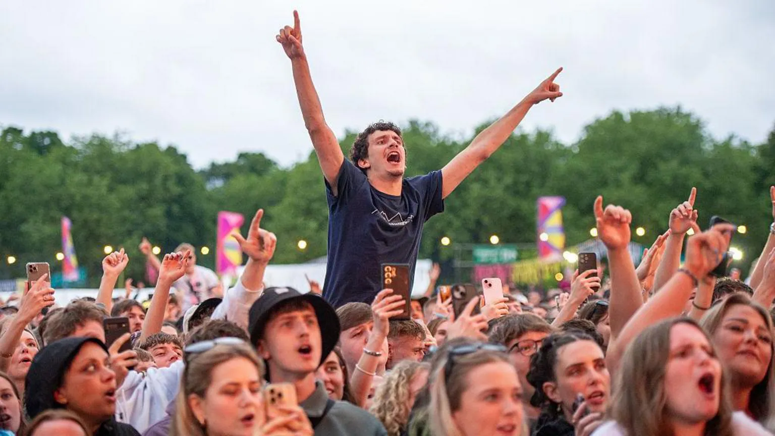 Getty Images Festivalgoers enjoy a performance during BBC Radio 1's Big Weekend. There are fans in the crowd who are singing along and one who is raised up with his arms in the air. 